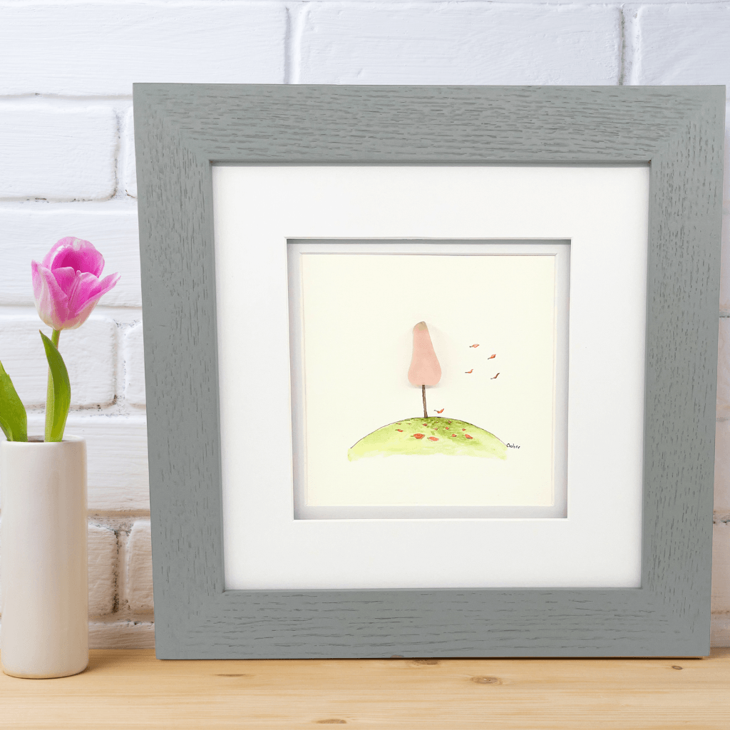 The Breast Cancer Tree original artwork featuring Depression era rose glass, displayed in a gray wood frame beside a pink tulip.