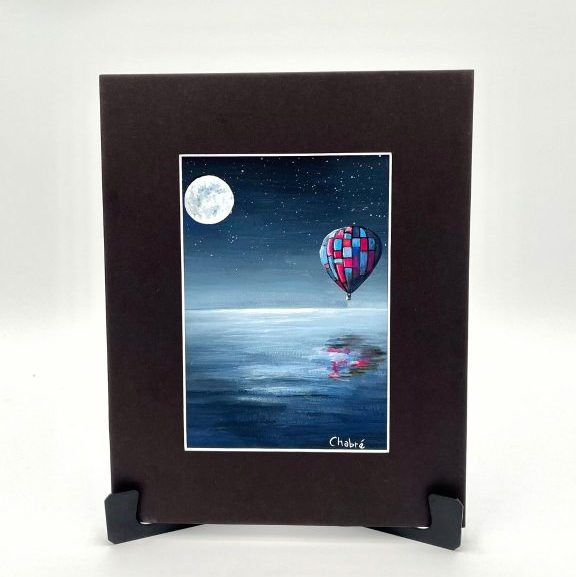 “Carry You” original Riverbed Art painting featuring a colorful hot air balloon floating over calm water at night beneath a full moon, with a soft reflection on the water’s surface.