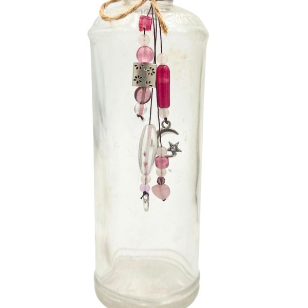 Upcycled LF glass bottle found in the Aroostook River, decorated with pink beads, charms, and twine