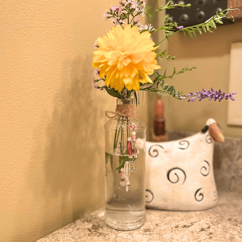 Vintage L.F. Medicine Co. bottle found in the Aroostook River, used as a vase with yellow and purple flowers