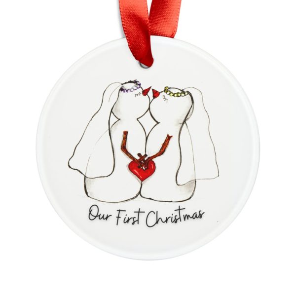 Two snowwomen holding a red heart on an acrylic “Our First Christmas” ornament with a red ribbon.