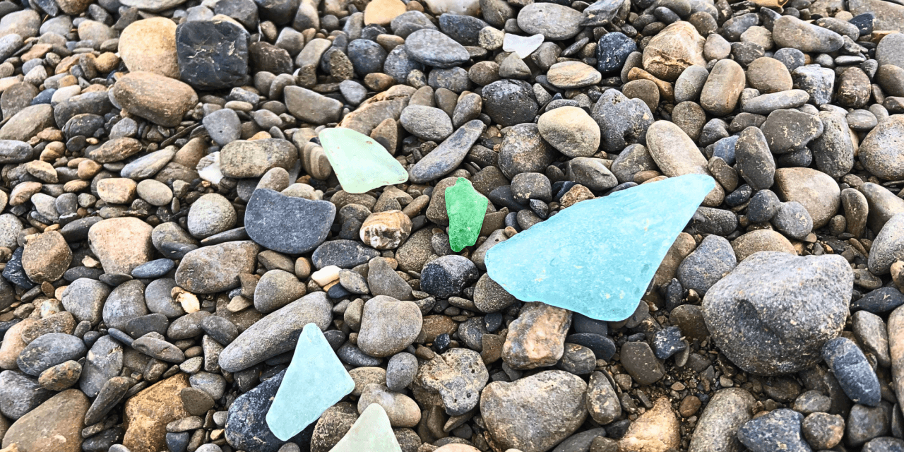 Glass pieces worn smooth by the river and pebbles scattered along the Aroostook Riverbed in Caribou, Maine.