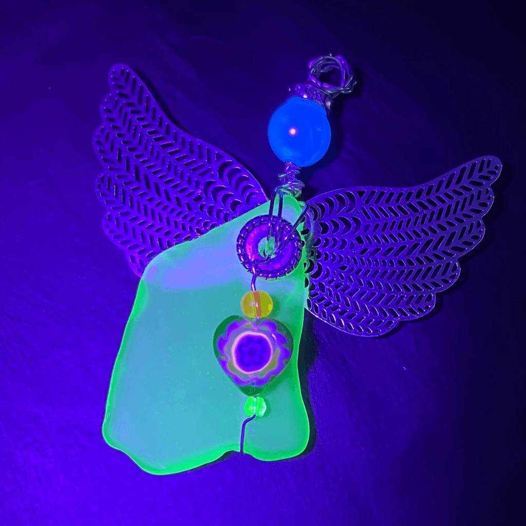 Uranium glass angel ornament glowing bright green under black light