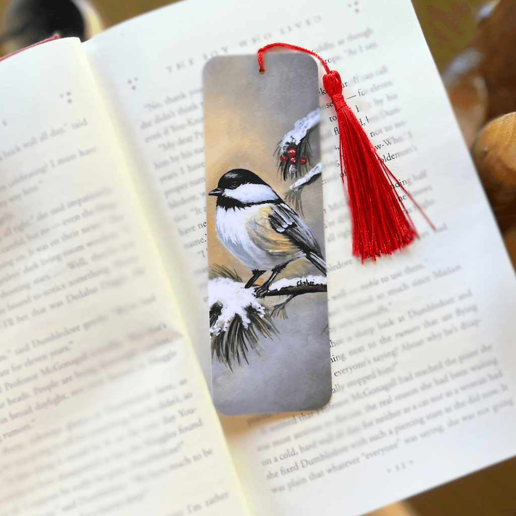 Winter Chickadee bookmark with tassel resting in an open book.