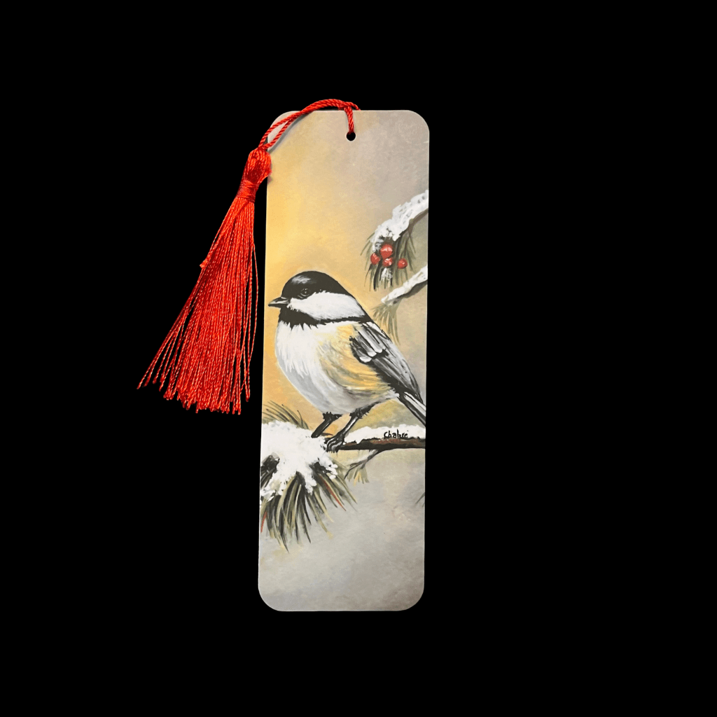 Handmade Winter Chickadee bookmark with red tassel, placed on black background.