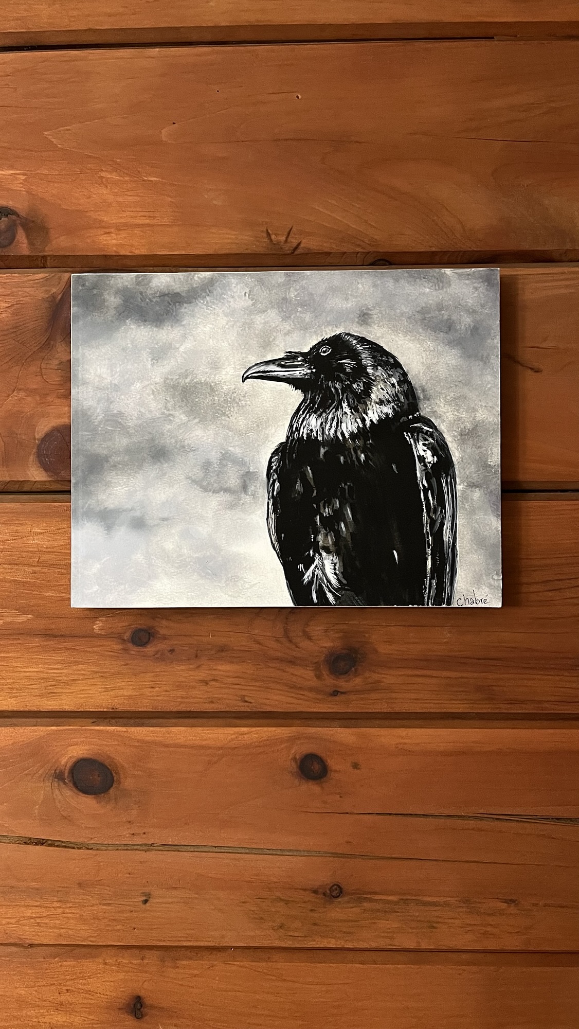 Black and white mounted print of a raven with cloudy background, sold Riverbed Art piece.