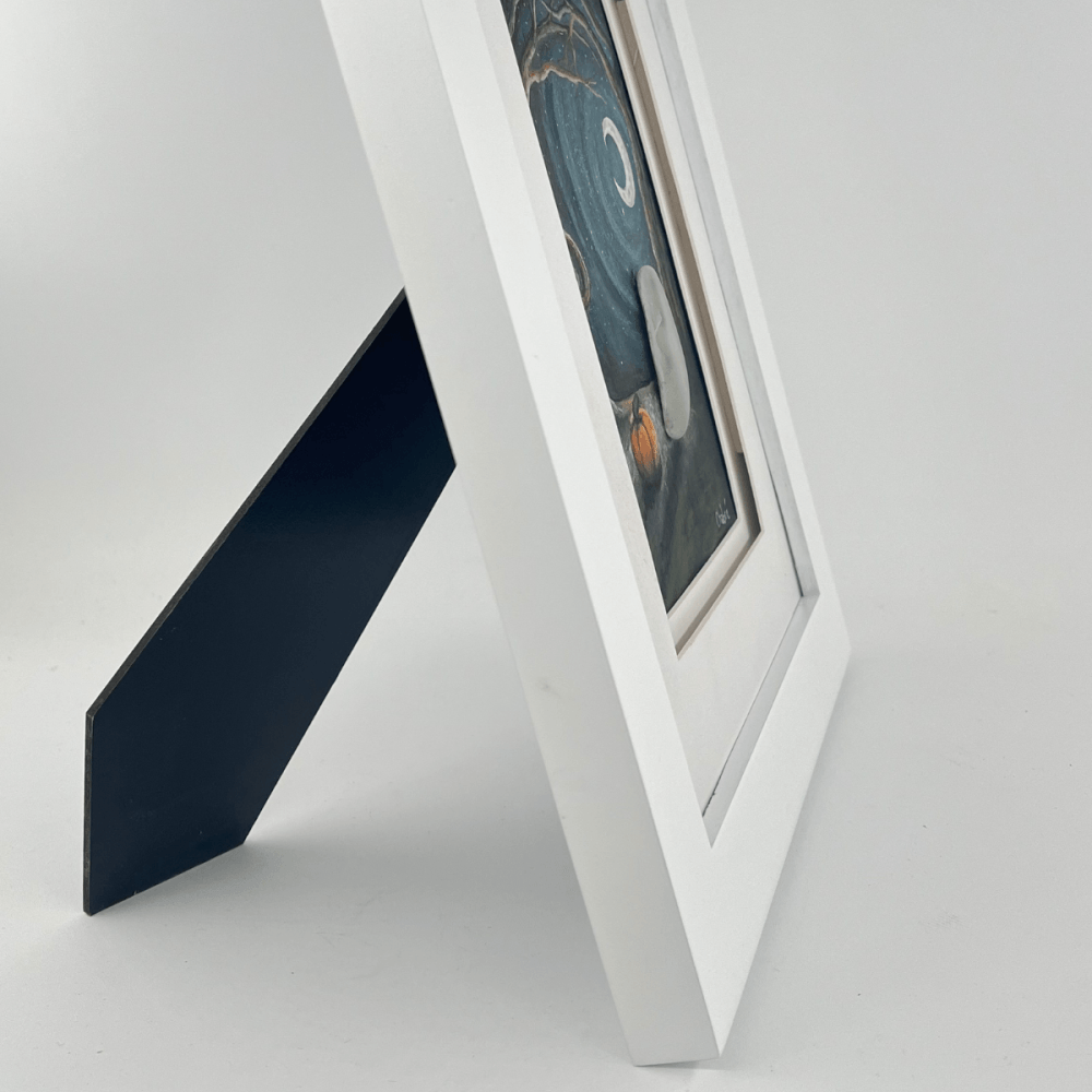 Side view of October Night Aroostook River Illustration framed in white wood with backing stand, showing its ready-to-display tabletop design.