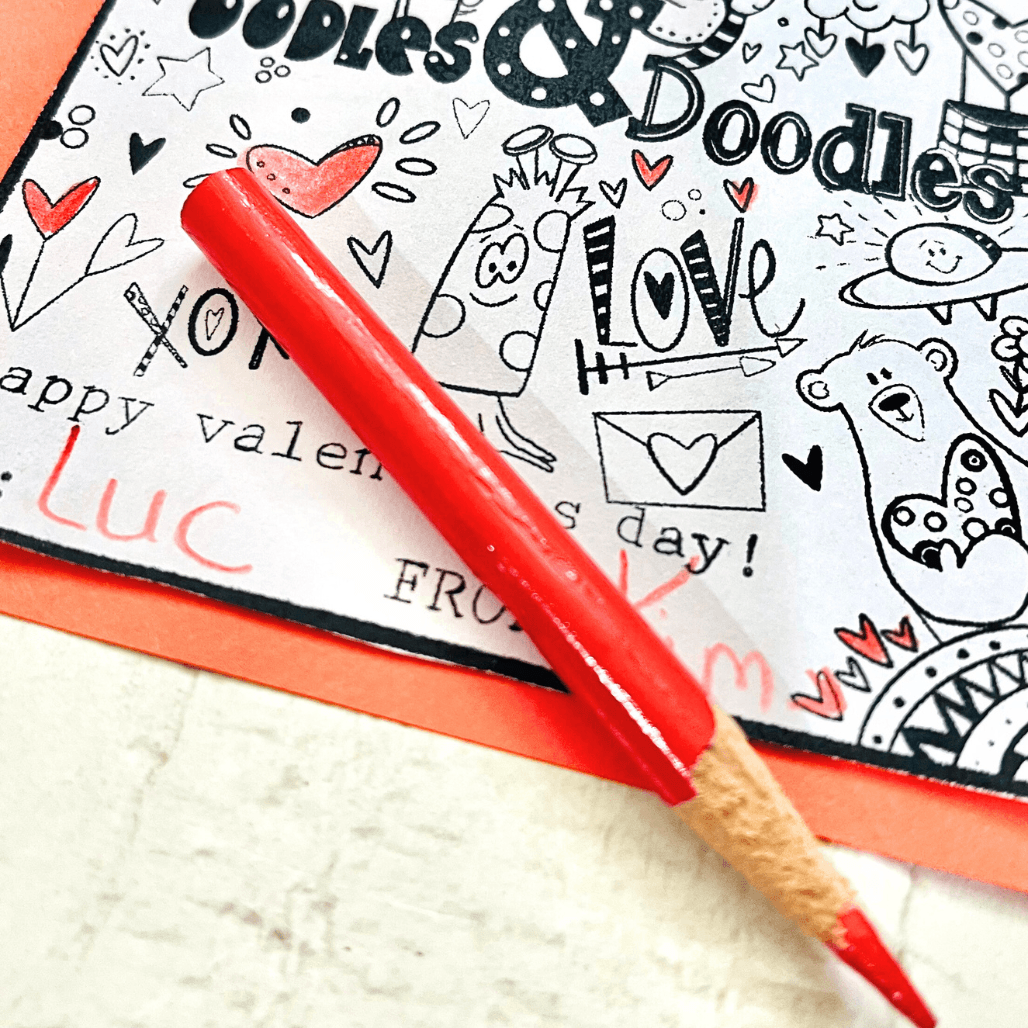 Valentine’s Day kids art project printable being colored with a red pencil on a finished Valentine card
