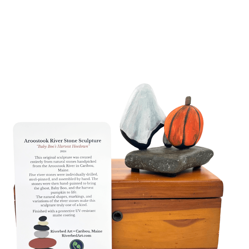Rear view of Baby Boo’s Harvest Hoedown stone sculpture beside its Riverbed Art information card