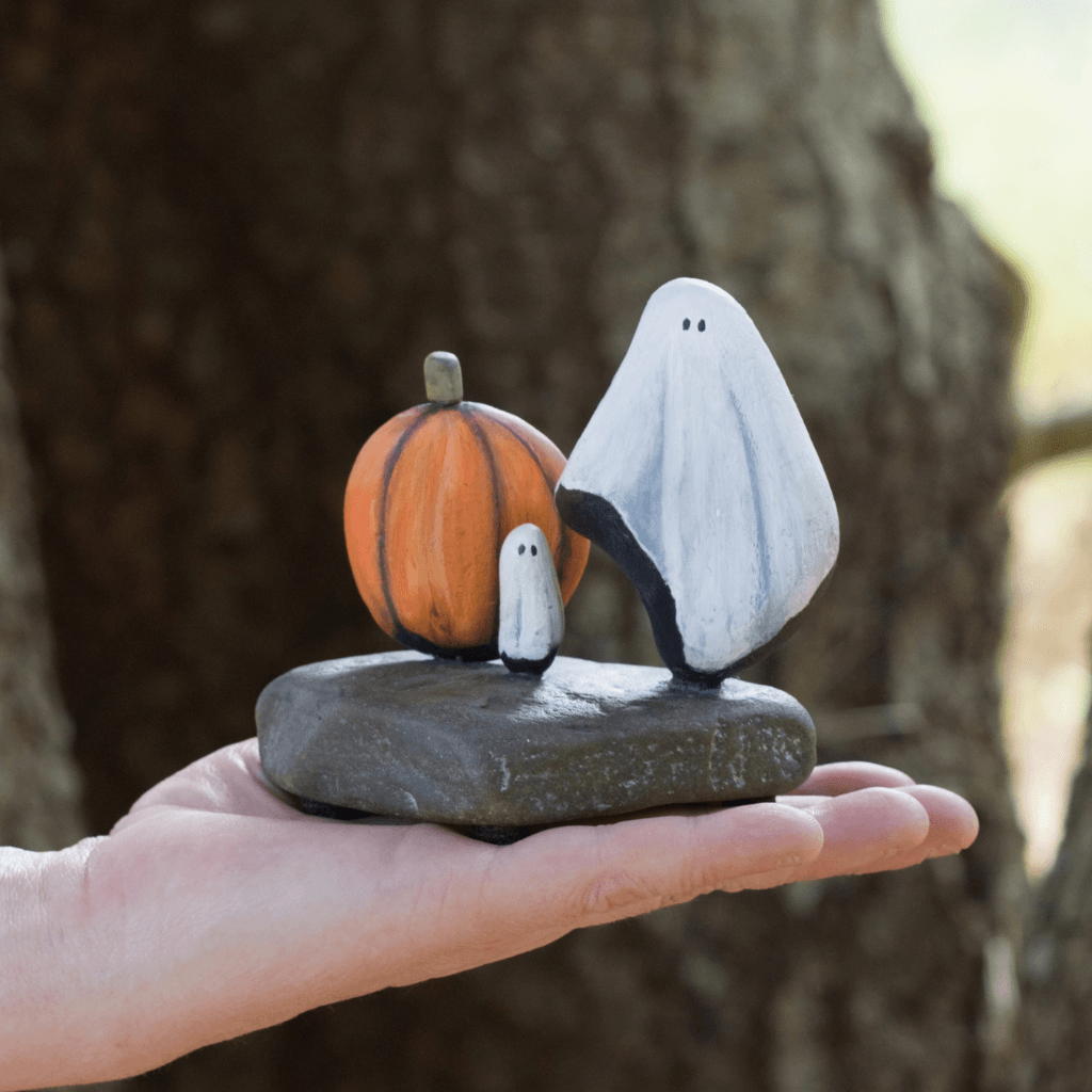 Baby Boo’s Harvest Hoedown ghost and pumpkin stone sculpture resting on an open hand to show its size