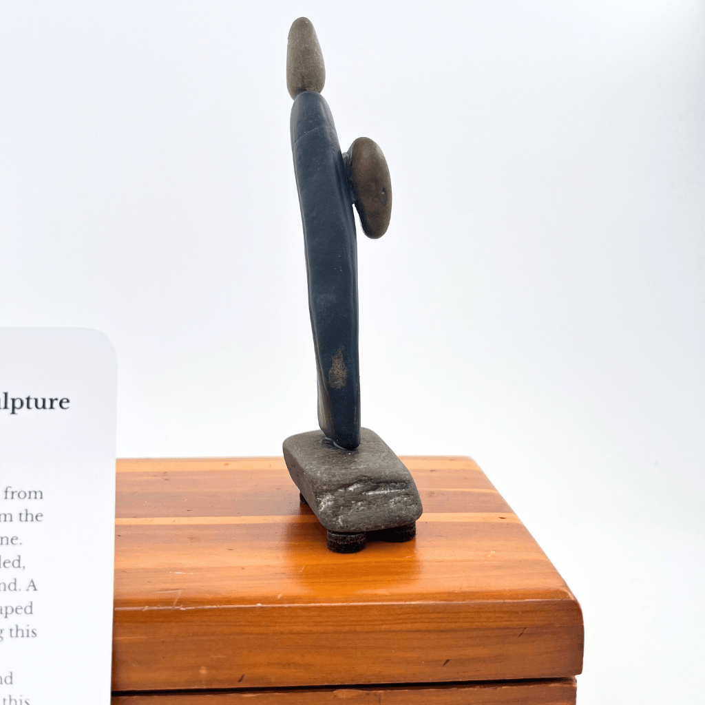 Side view of I Give You My Heart stone sculpture showing the heart projecting from the slender body.