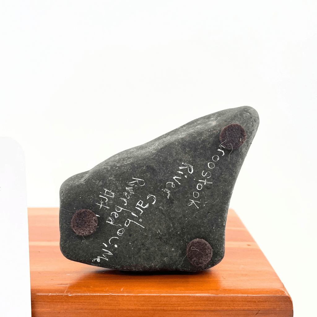 Underside of Pumpkin Patch Love stone base with Riverbed Art inscription, Aroostook River origin, and three felt feet.
