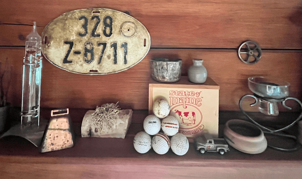 Collection of objects found in the Aroostook River, including a German license plate, golf balls, and metal gear.