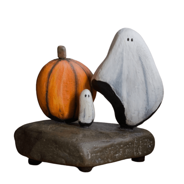 Aroostook River stone sculpture featuring two white ghosts and an orange pumpkin on a natural stone base