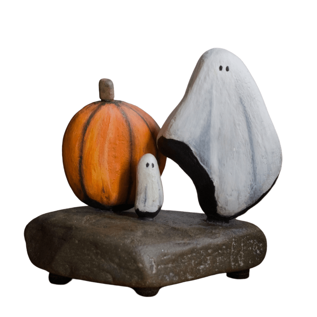 Aroostook River stone sculpture featuring two white ghosts and an orange pumpkin on a natural stone base