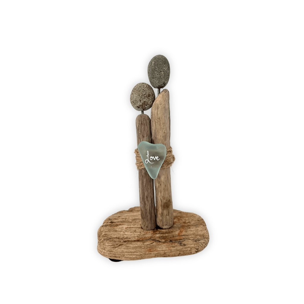 Couple with river pebble heads, driftwood bodies, and a river glass heart